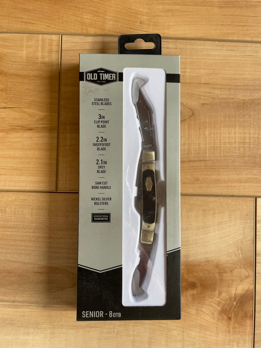 A knife with a mirror finish stainless clip, sheepsfoot, and spey blades, sawcut bone handle, nickel silver bolster, and inlay shield, packaged in a cardboard box with a hanging tab.